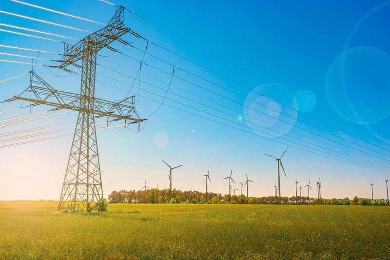 industrial-high-voltage-power-line-pylons-and-wind-turbines-2216804985